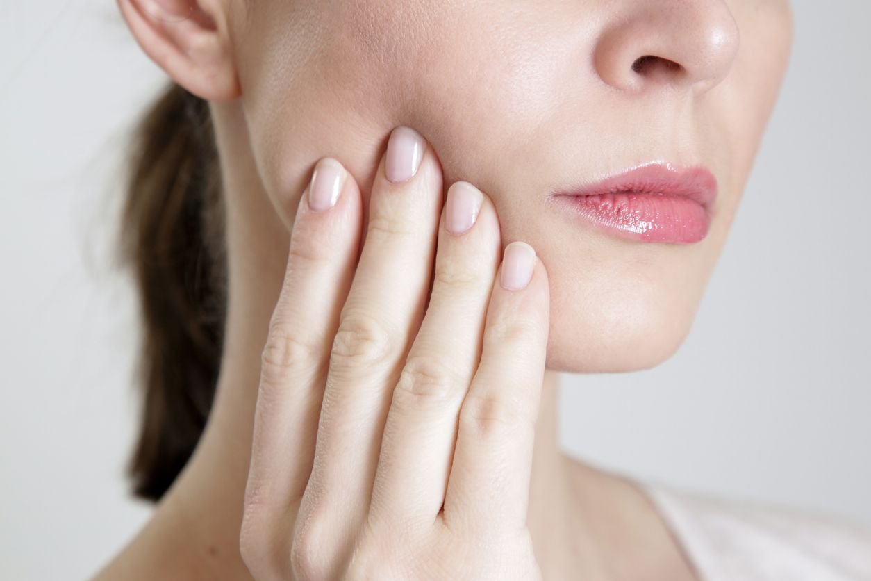 woman holding jaw with teeth grinding pain